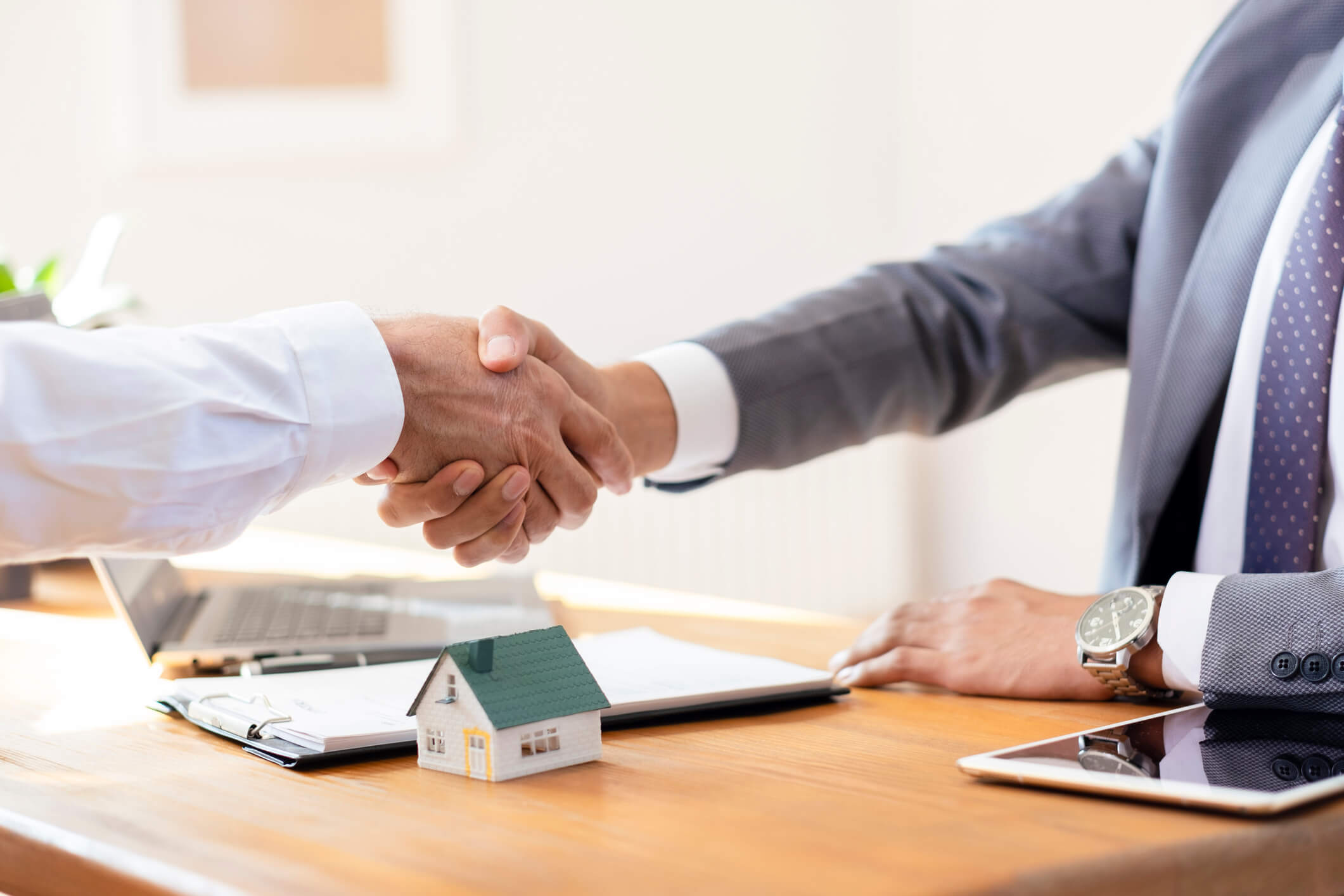 Two professionals shaking hands over contract