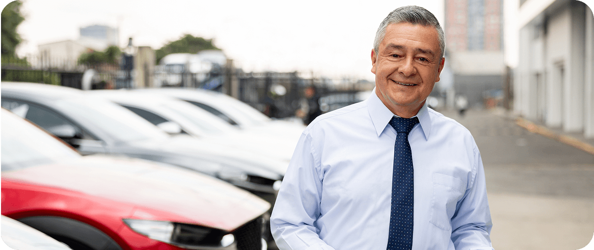 Man smiling near parked cars
